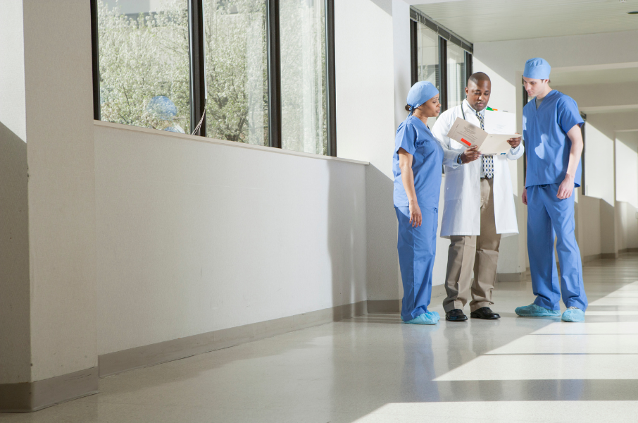 doctor and two nurses review chart in hospital